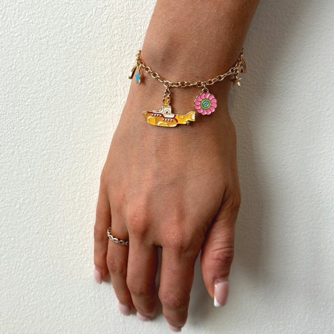 Pulsera dorada con charms del Submarino amarillo, tema de los Beatles, detalle en mano