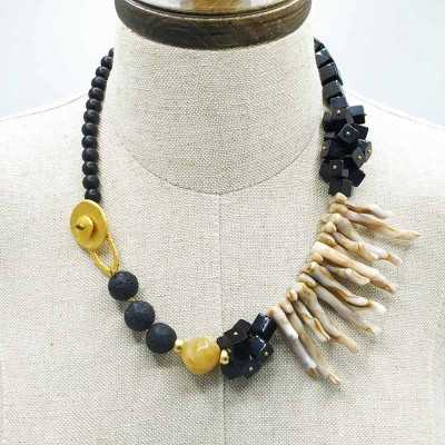 Vista detalle del collar Monsul con sus fornituras en oro mate y coral sintetico.