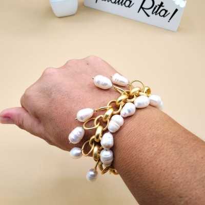 Pulsera de cadena dorado mate y perlas naturales Töölö de la marca Maldita Rita, en mano