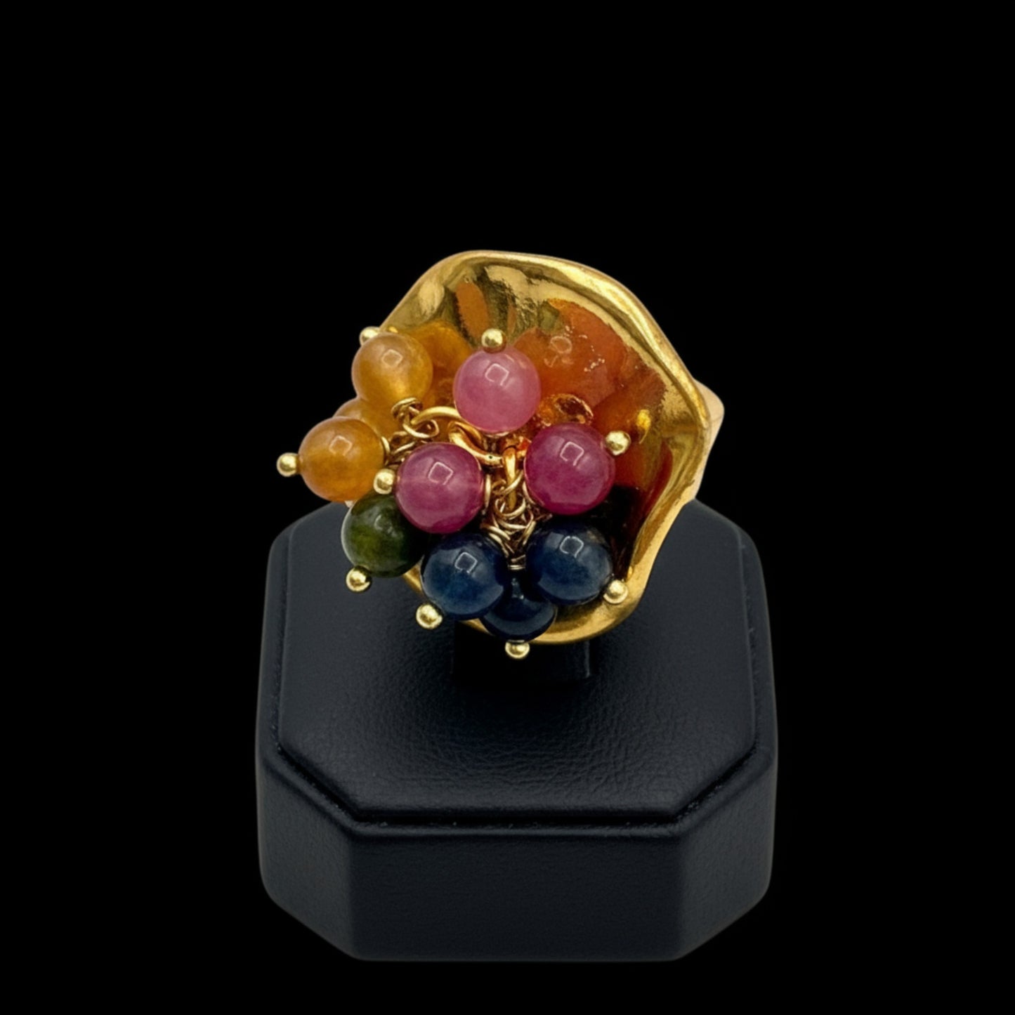 Anillo dorado grande con bolitas de piedras naurales de la marca Maldita Rita, expositor negro