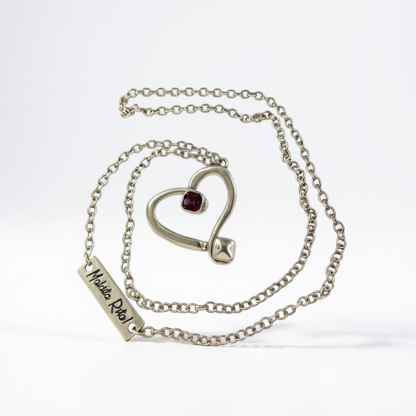 Colgante en plata en forma de corazón hueco con un cristal de Swarovsli auténtico y el logo de Maldita Rita, en color morado