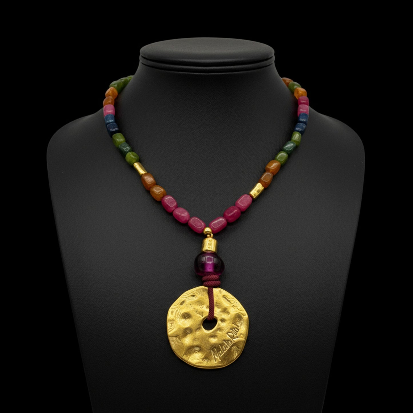 Collar corto con medallón dorado y piedas naturales de Maldita Rita Joyería.  Sobre busto negro