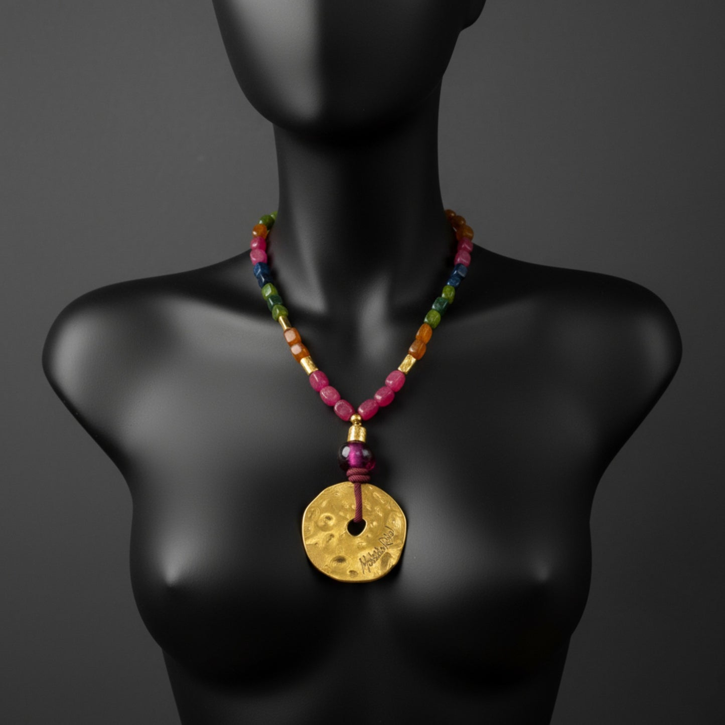 Collar corto con medallón dorado y piedas naturales de Maldita Rita Joyería.  Sobre maniquí on cabeza en negro