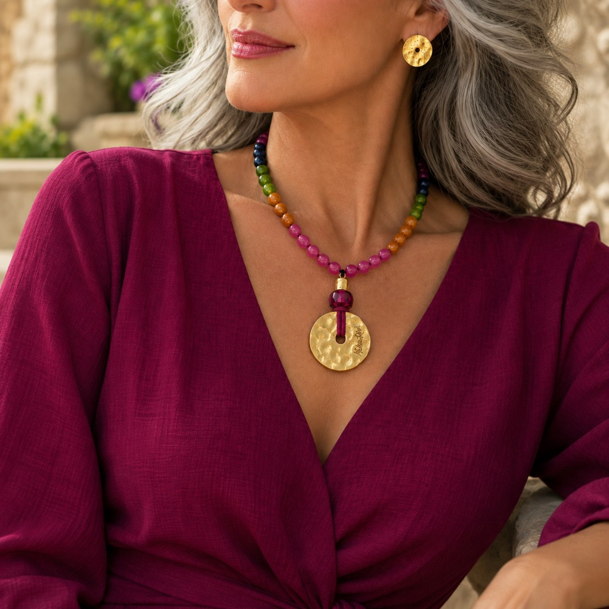 Collar de piedras naturales y medallón con baño de oro corto, colección Lunática de Maldita Rita Joyería. Visto con vestido color magenta.