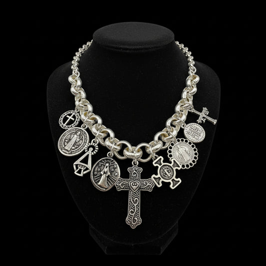 Collar Madonna, cadena con colgantes de vírgenes, santos y cruces, de la marca Maldita Rita. Sobre busto negro.