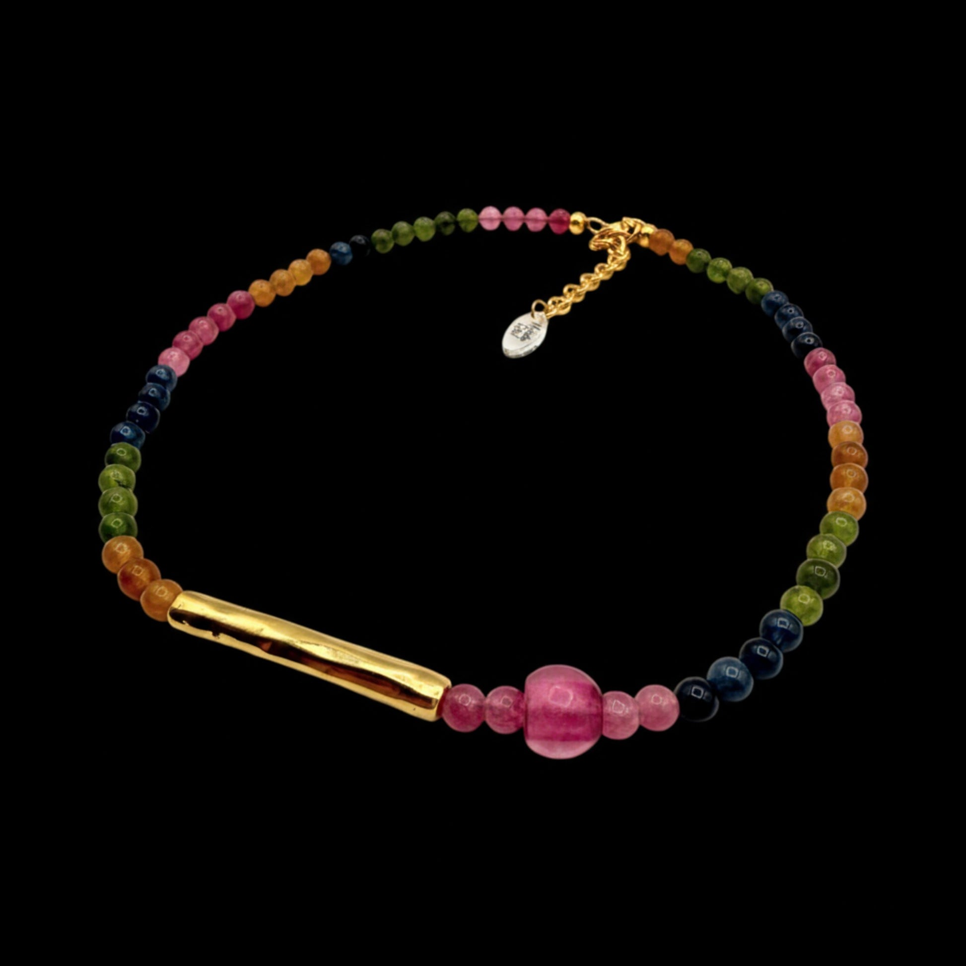 Gargantilla de piedras naturales en diferentes colores y tubo dorado, de Maldita Rita Joyería, sobre fondo negro