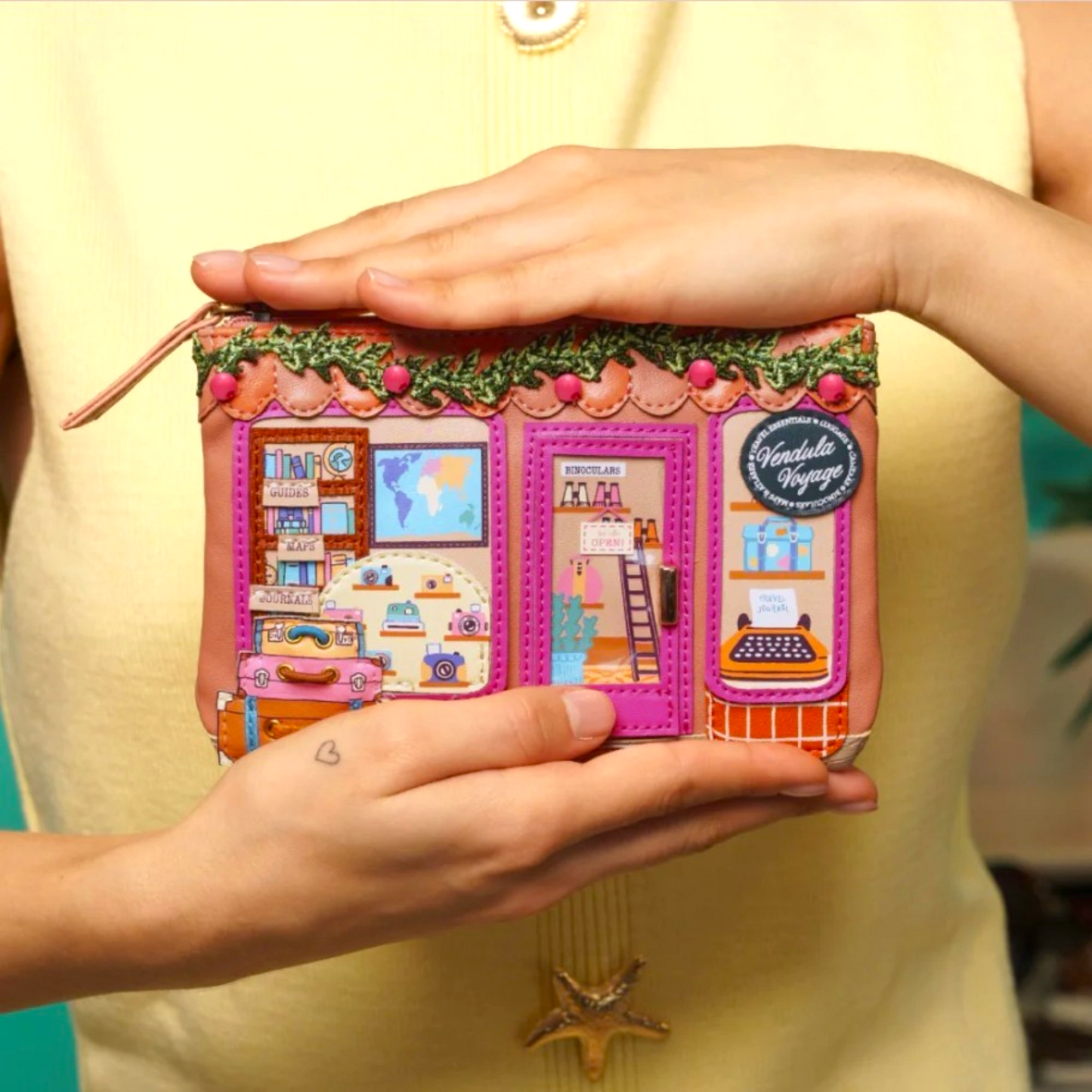 Monedero con cremallera y tarjetero Vendula Voyage, de Vendula London, venta en Maldita Rita. Visto en manos de modelo.