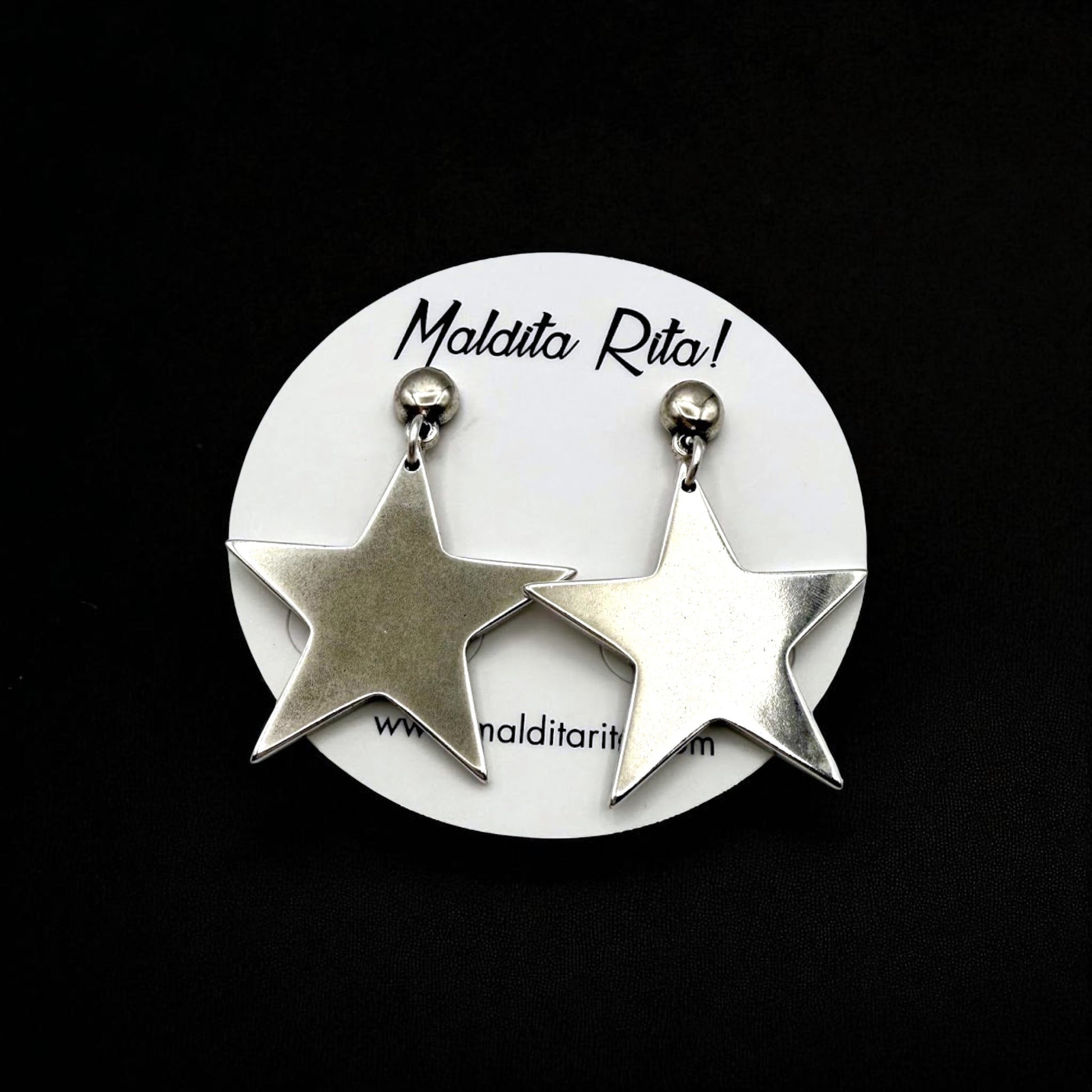 Pendiente Black Star de Maldita Rita, sobre fondo negro