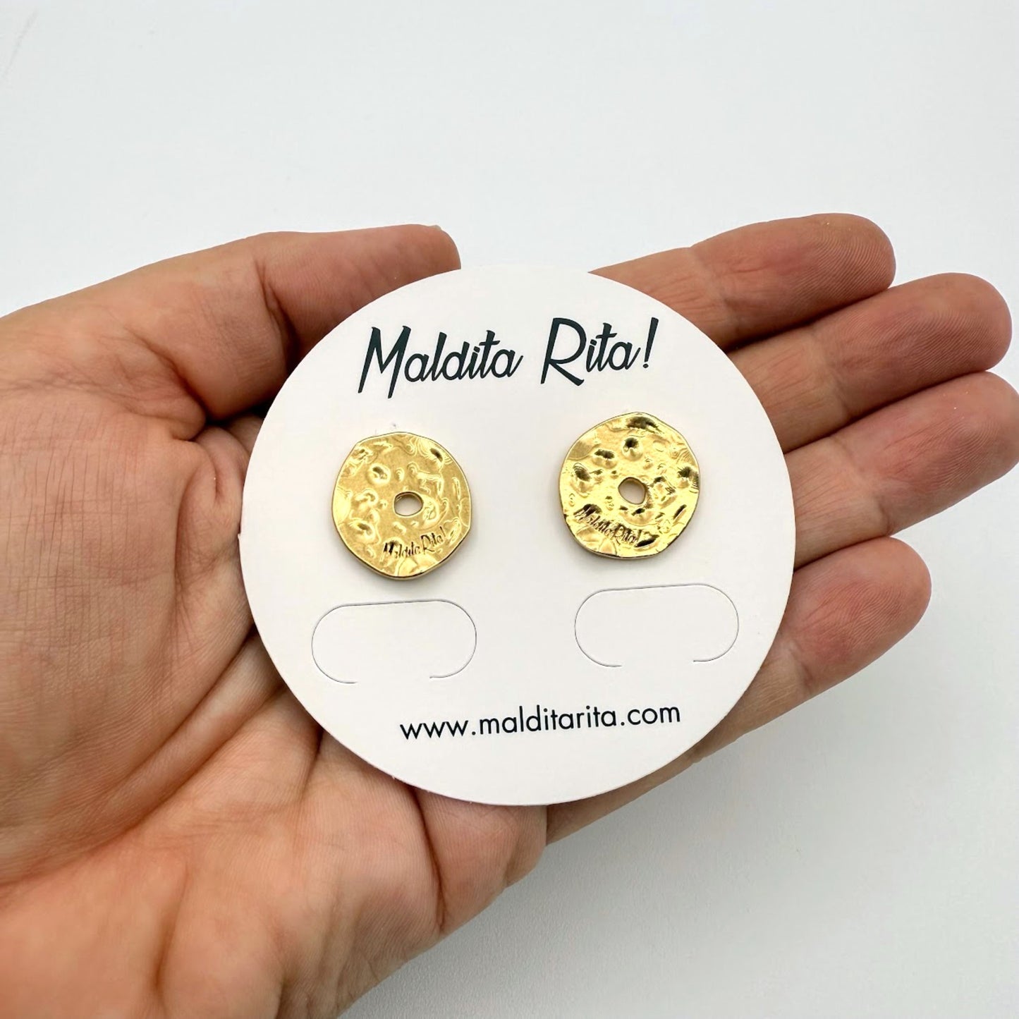 Pendientes Lunática oro de Maldita Rita, redondos irregulares, detalle vistos en la mano