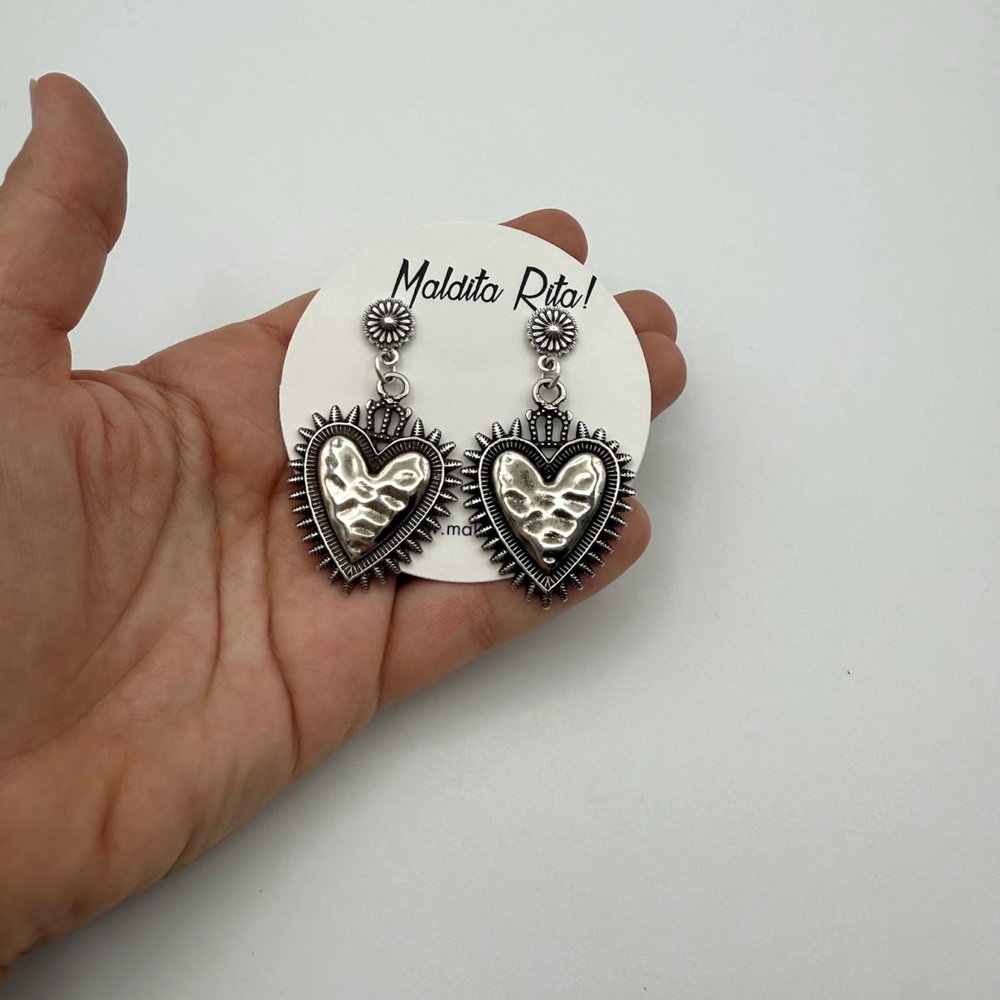 Pendientes Milagrito plata de la marca almeriense Maldita Rita, vista en mano