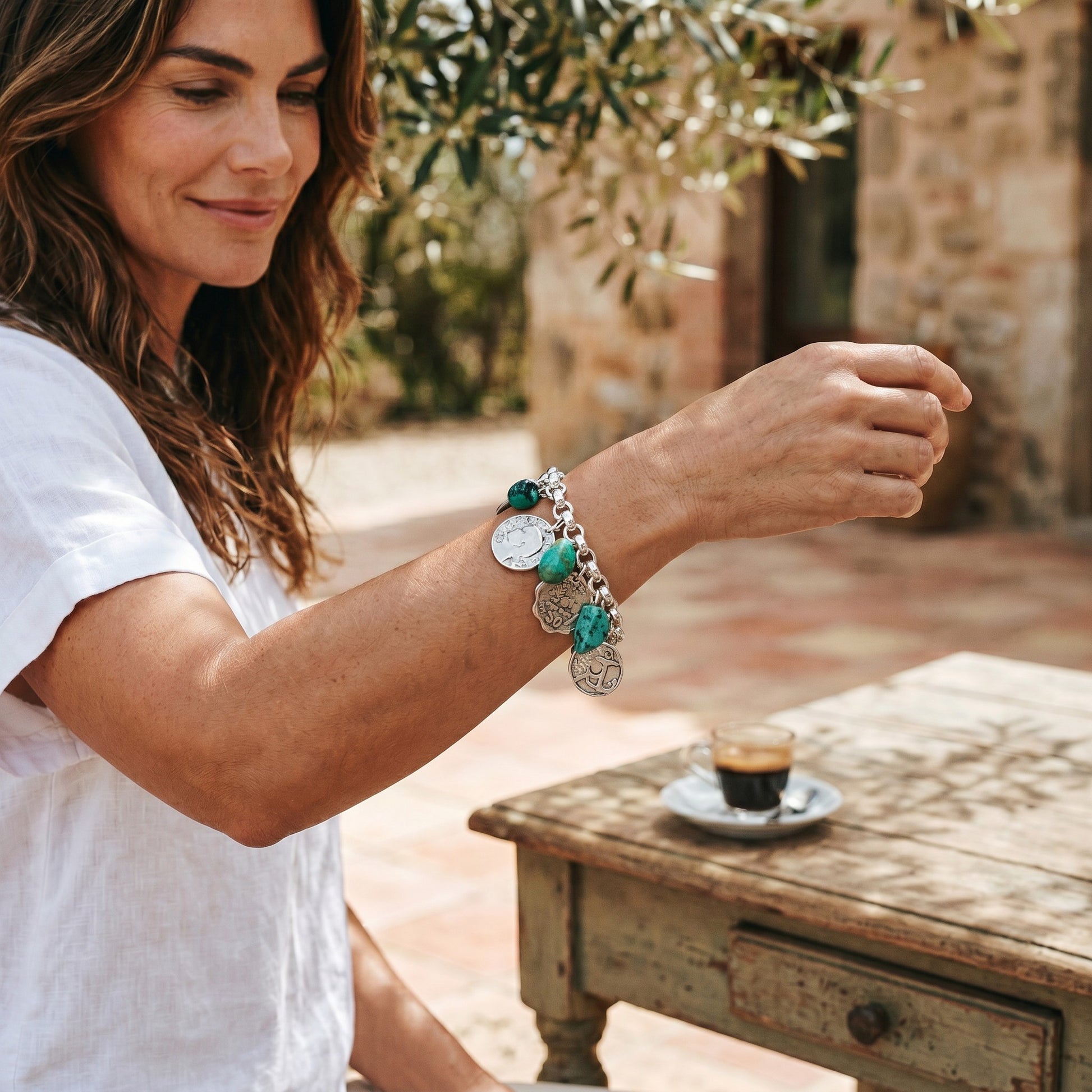 Pulsera de cadena con colgantes de turquesas y monedas plata de la marca Maldita Rita. Imagen con modelo